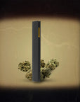 Black vape pen with cannabis buds on a textured beige background